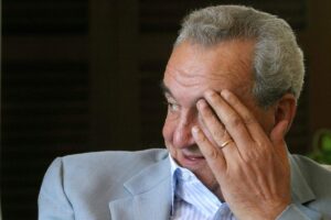 Bruno Pizzul di profilo con una mano sulla fronte