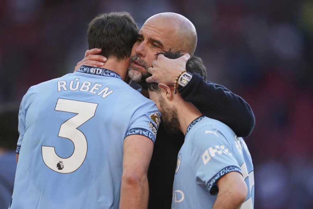 Pep Guardiola con due giocatori del Manchester City