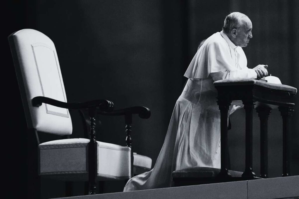 Papa Francesco immortalato inginocchiato in bianco e nero