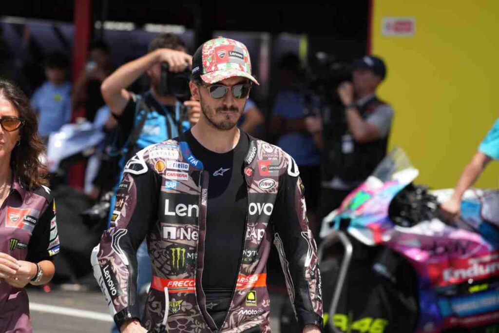 Bagnaia cammina mesto con la testa china con indosso la tuta della Ducati