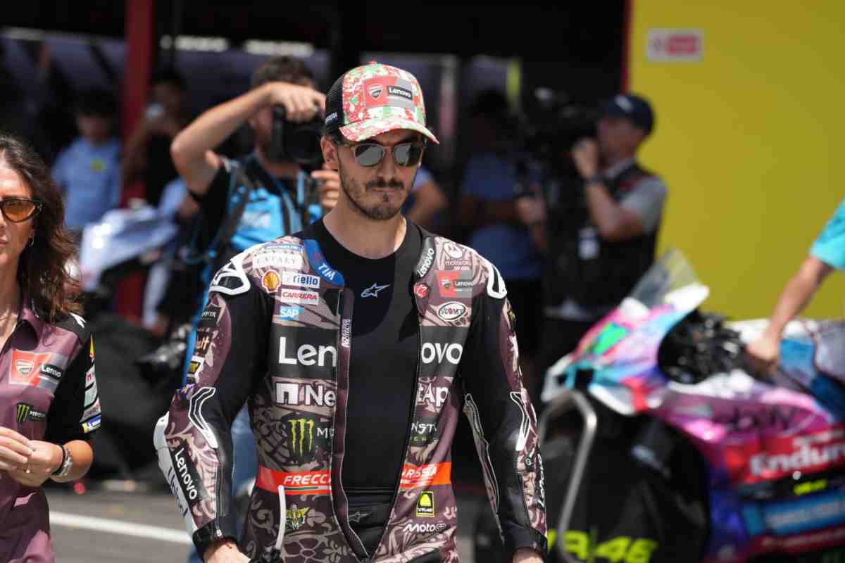 Bagnaia cammina mesto con la testa china con indosso la tuta della Ducati