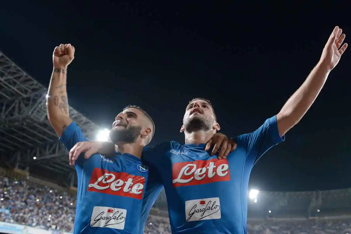 Insigne a sinistra e Mertens a destra abbracciati mentre saltano con i tifosi con indosso la maglia del Napoli