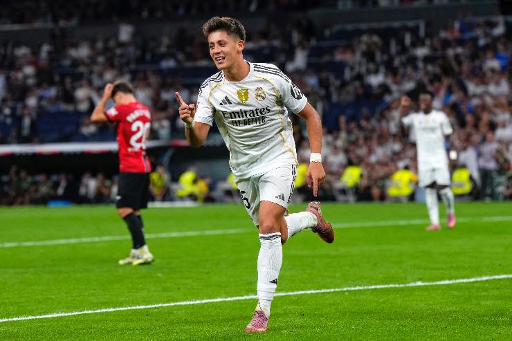 Arda Güler esulta dopo un gol con il Real Madrid durante una partita della Champions League nel 2025, mostrando gioia e determinazione mentre i compagni lo festeggiano.