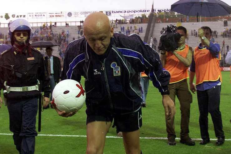 Pierluigi Collina cammina con il pallone in mano sul campo allagato durante Perugia–Juventus 2000 al Renato Curi.