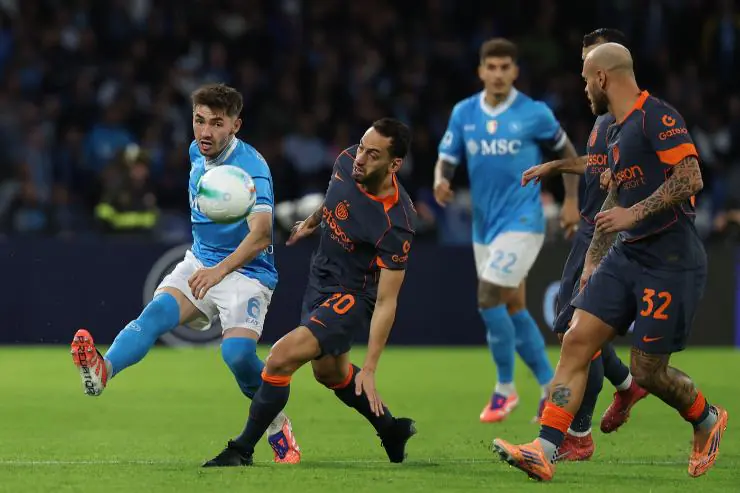 Un’azione di gioco tra Napoli e Inter durante una partita di Serie A 2025, con un contrasto tra centrocampisti per il possesso palla.