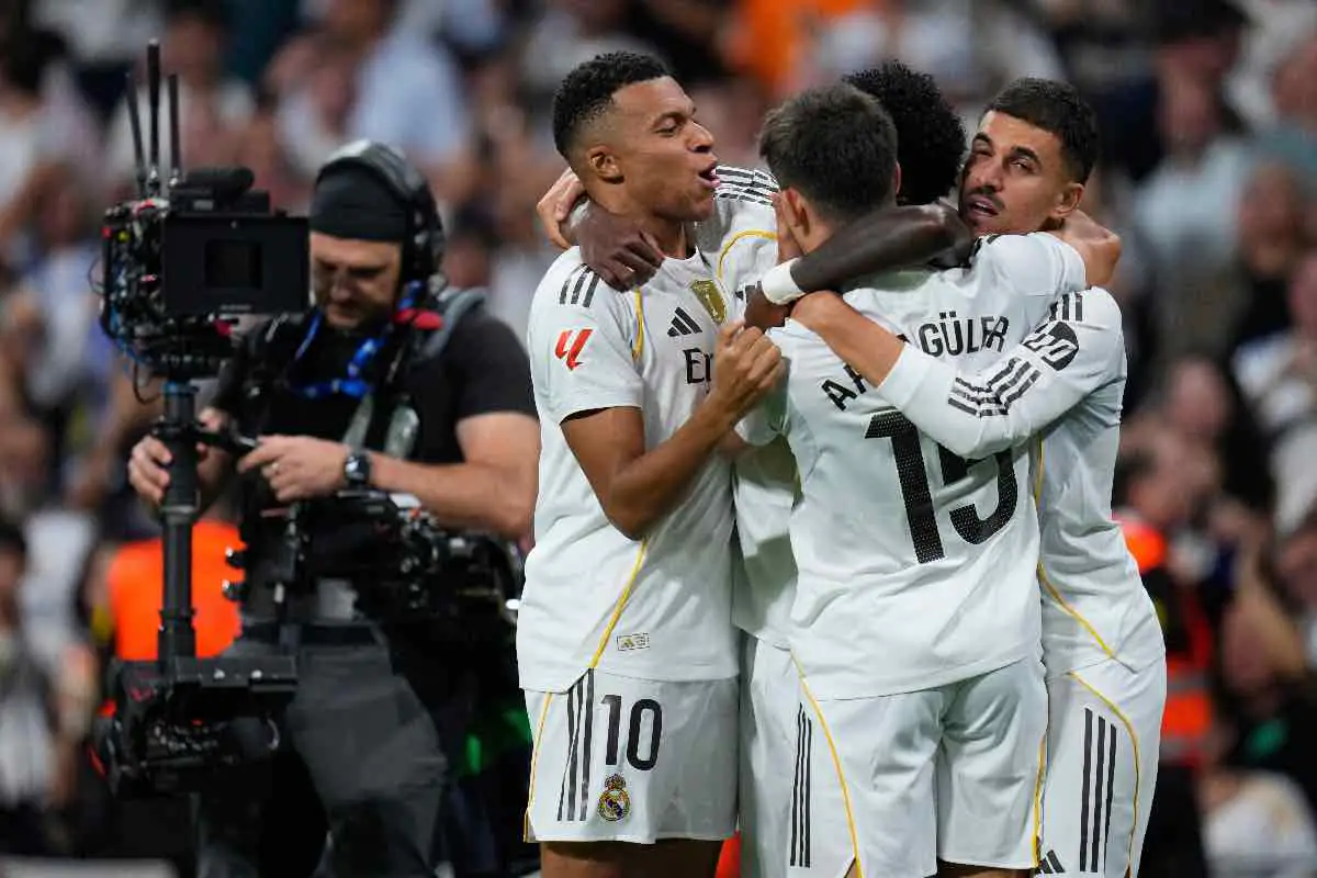I giocatori del Real Madrid festeggiano insieme dopo un gol segnato durante una partita della Champions League nel 2025, con Arda Güler, Vinícius Júnior, e altri compagni di squadra.