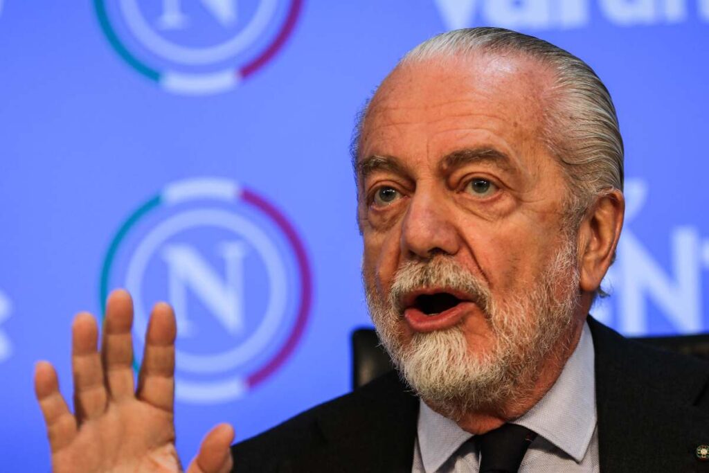Aurelio De Laurentiis interviene durante una conferenza del Napoli davanti al pannello con il logo del club.