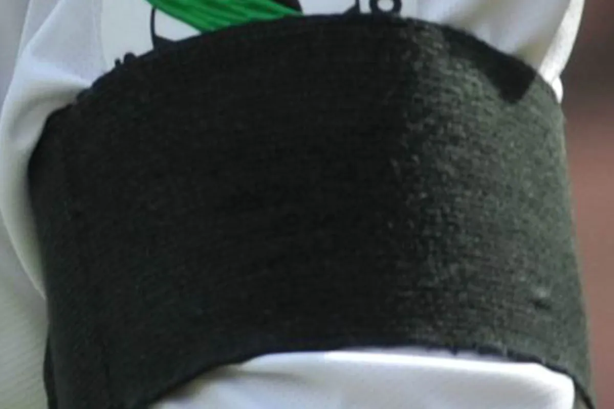 Fascia nera al braccio di un calciatore della Serie A in segno di lutto, sopra il logo della Lega Calcio.